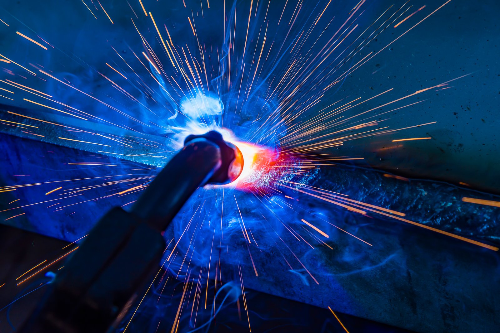 Industrial welder using MIG torch on construction site